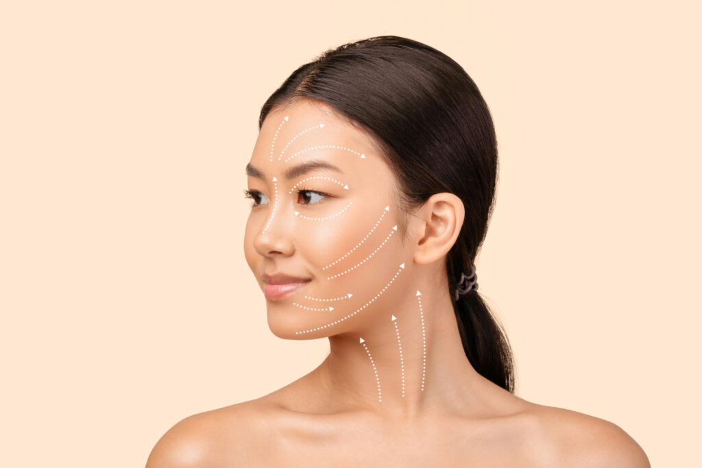 Woman with dotted white arrows on face showing facial contour lines for skincare guidance, calm peach background.